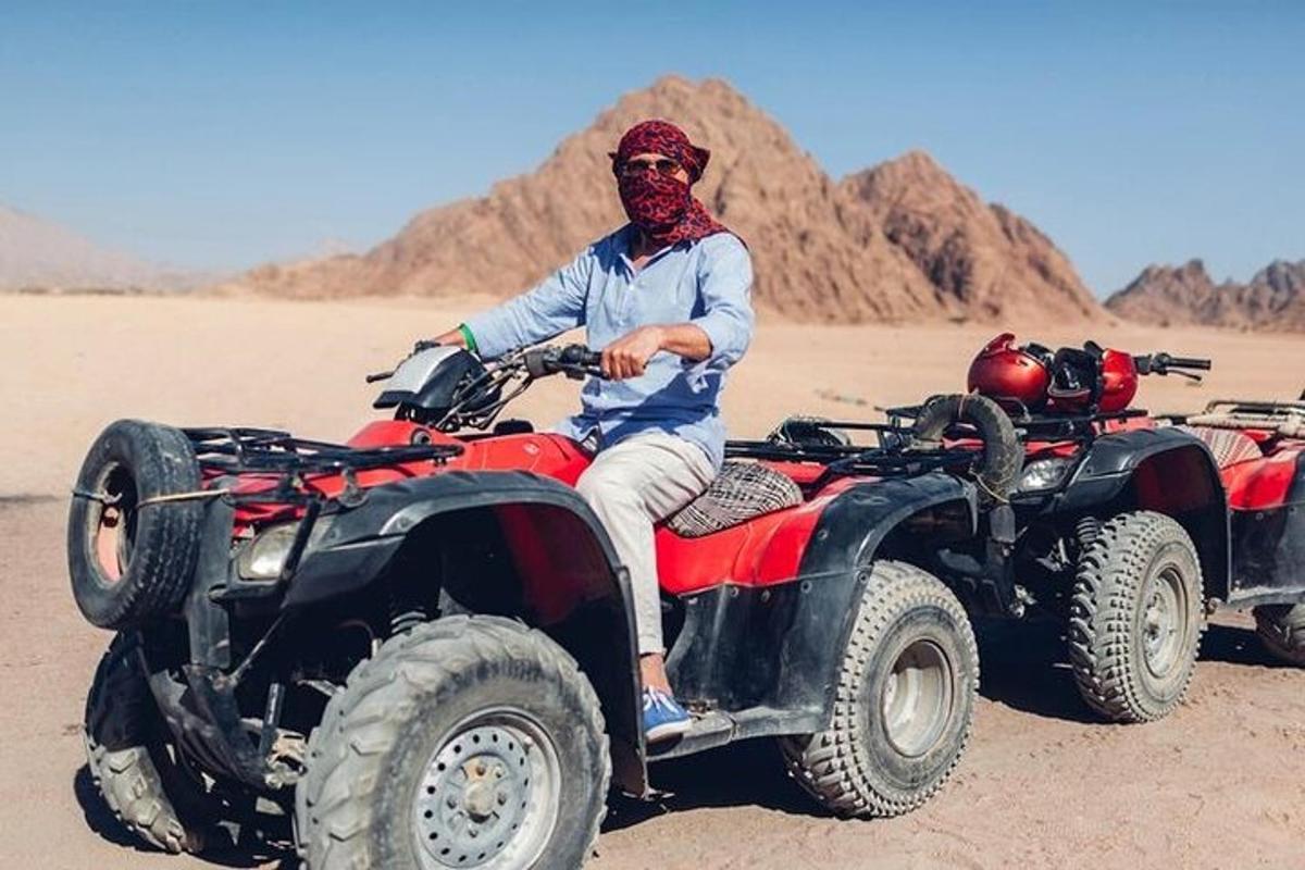 ein Mann sitzt auf einem Quad in der Wüste