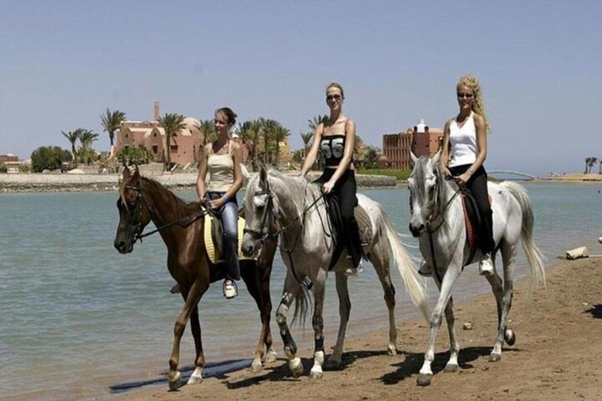 Három nő lovagol a tengerparton