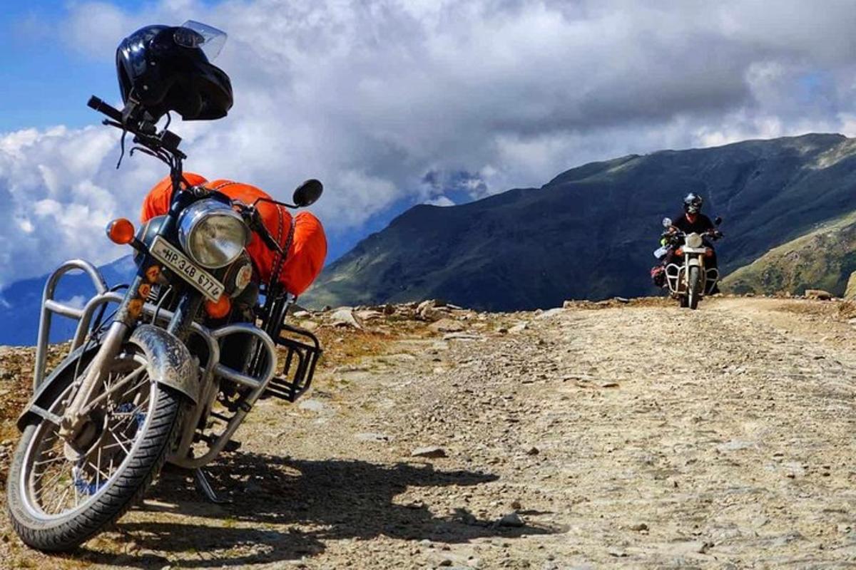 two people riding motorcycles on a dirt road