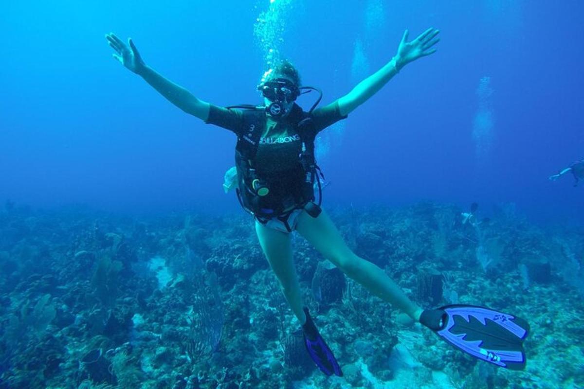 a woman in the ocean with her arms in the air