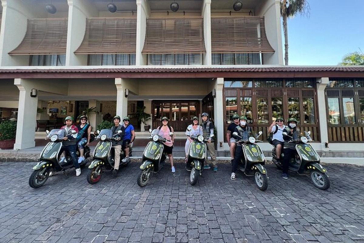 un gruppo di persone sedute su scooter davanti a un edificio