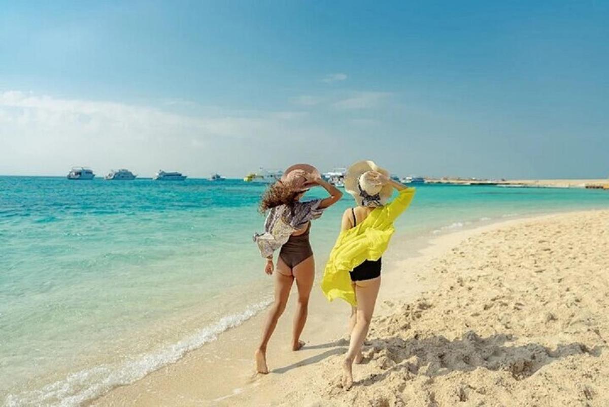 two women are walking on the beach