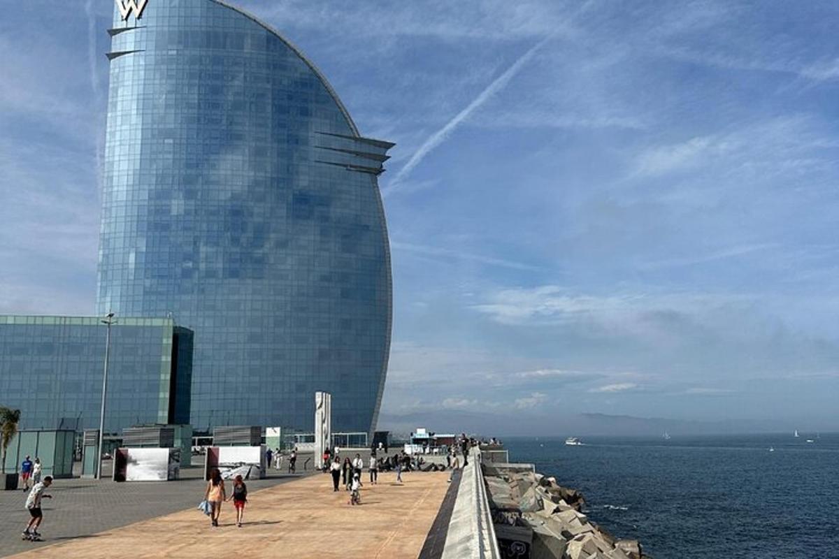 ein Gebäude mit Menschen, die auf einem Pier neben dem Wasser spazieren gehen