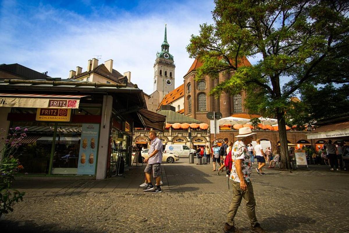 skupina lidí jdoucích po ulici s hodinovou věží