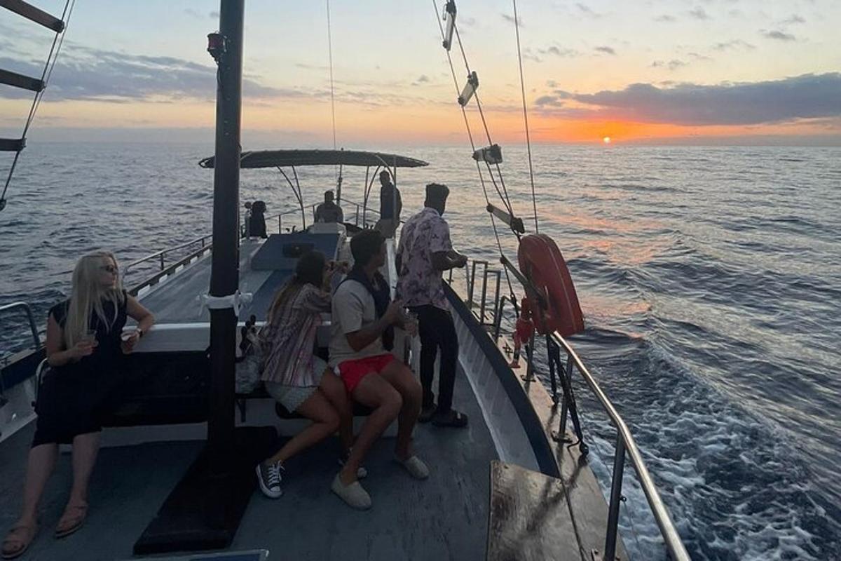 un grup de oameni care stau pe o barcă în ocean