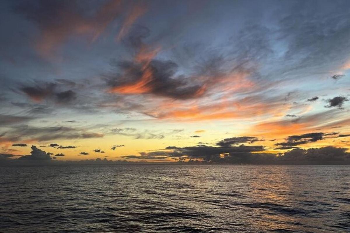 una posta de sol sobre l'oceà amb un cel ennuvolat