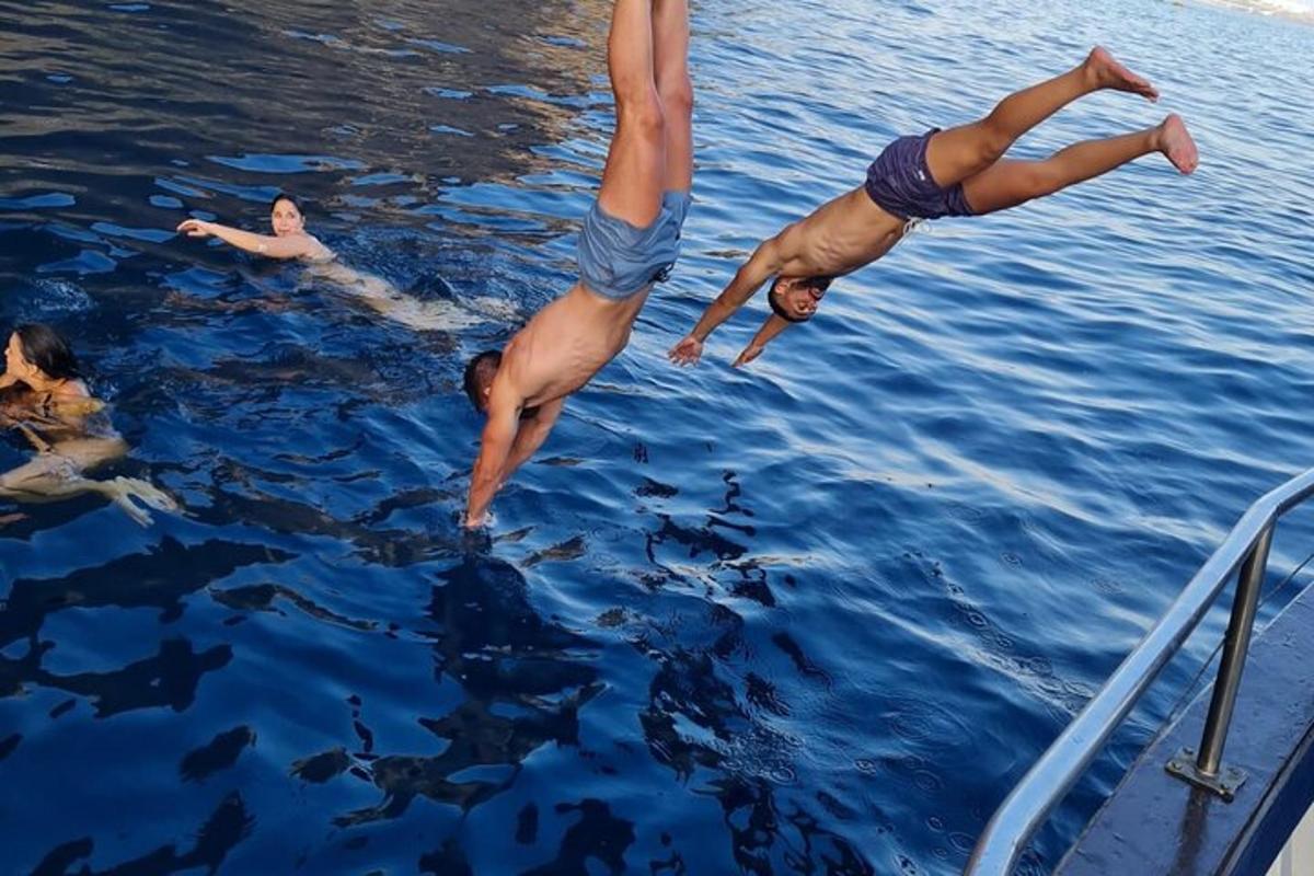 duas pessoas mergulhando na água de um barco