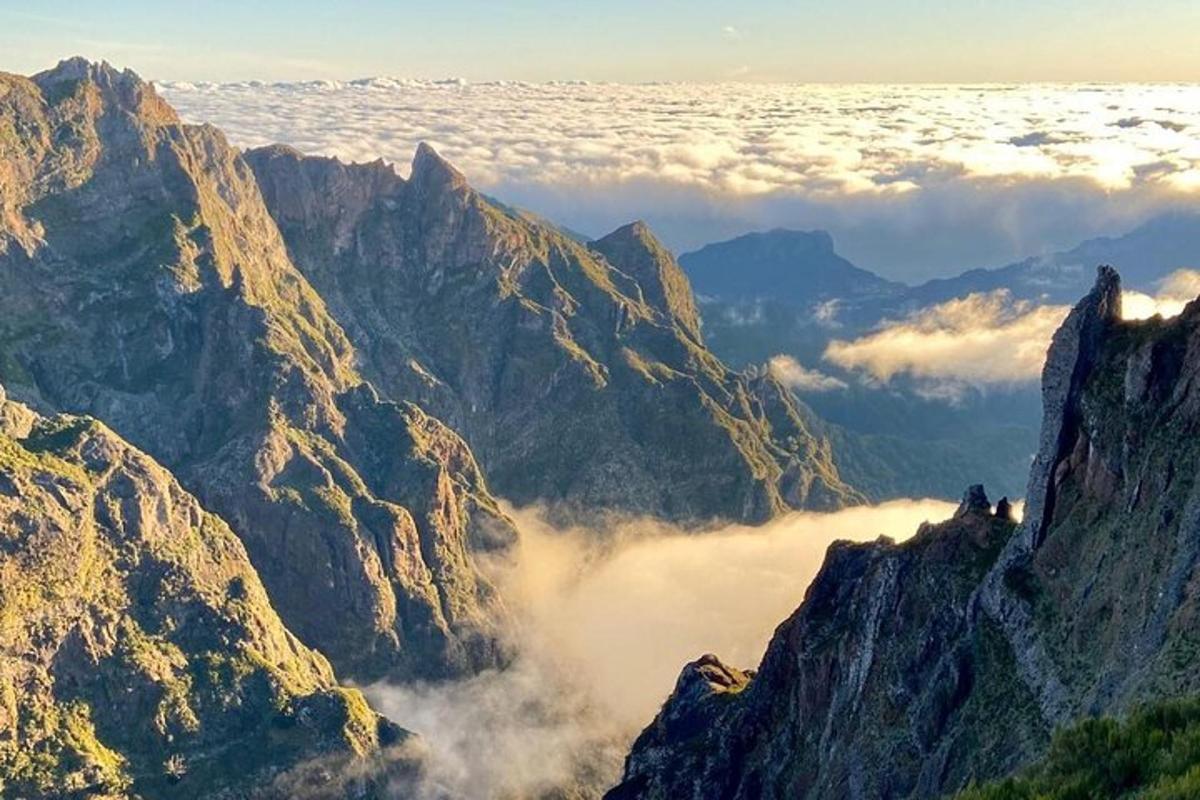 uma vista de uma cadeia de montanhas com nuvens no vale