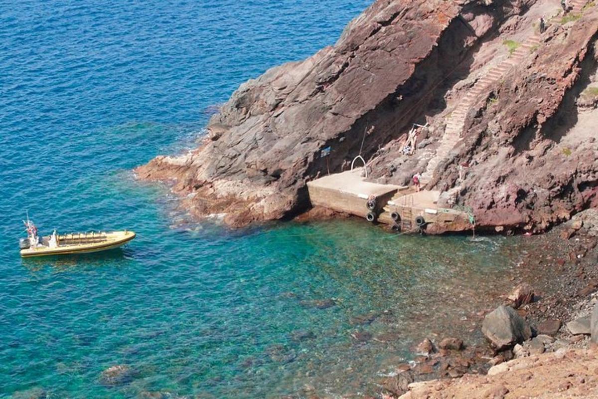 bátur í vatninu við hliðina á kletti