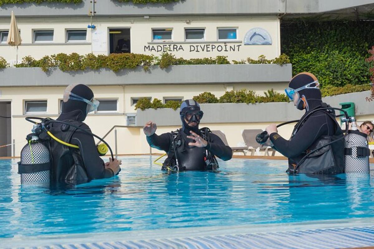 três pessoas na água de uma piscina