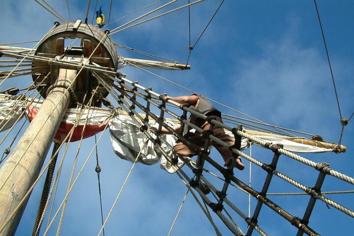 a man climbing on the rigging of a pirate ship