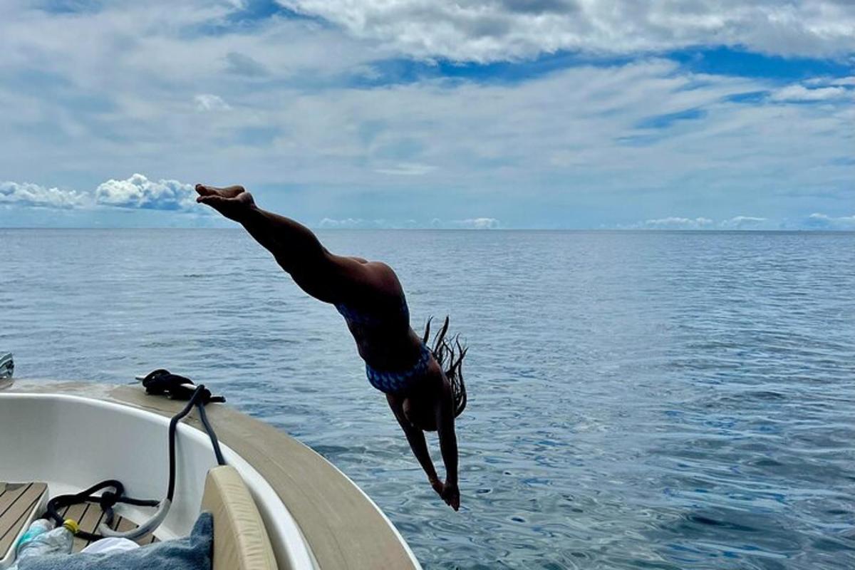 een man die van een boot in het water springt