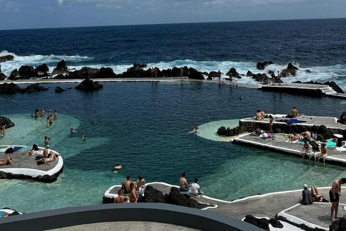 a group of people in a swimming pool near the ocean