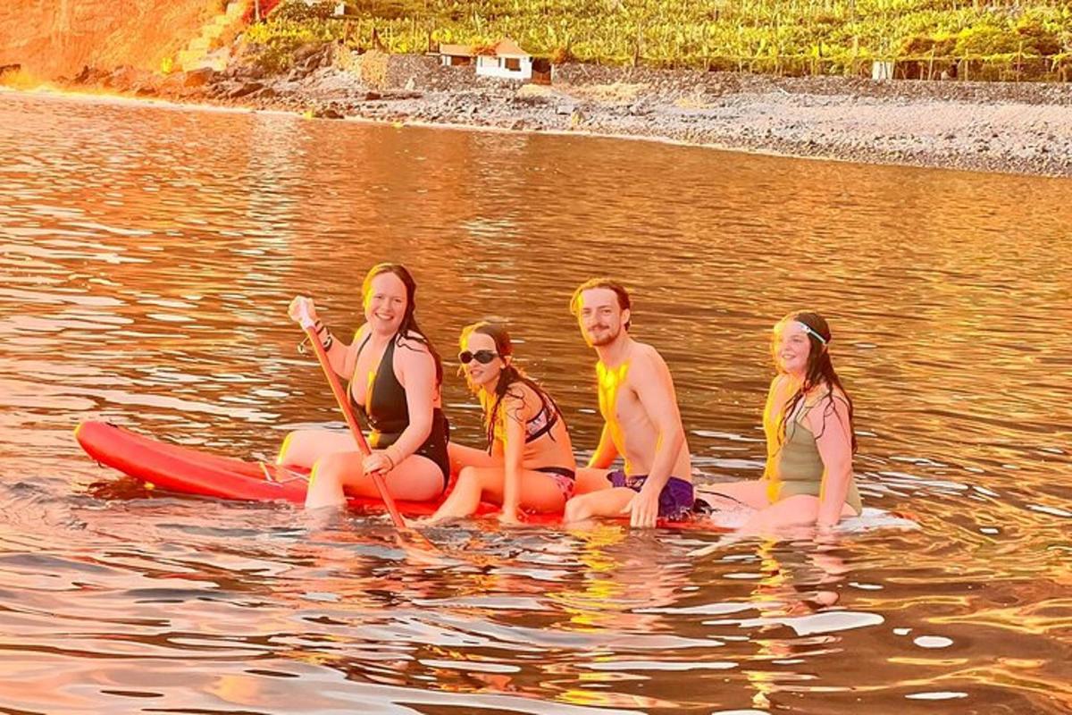 un gruppo di persone sedute su una tavola da paddle in acqua
