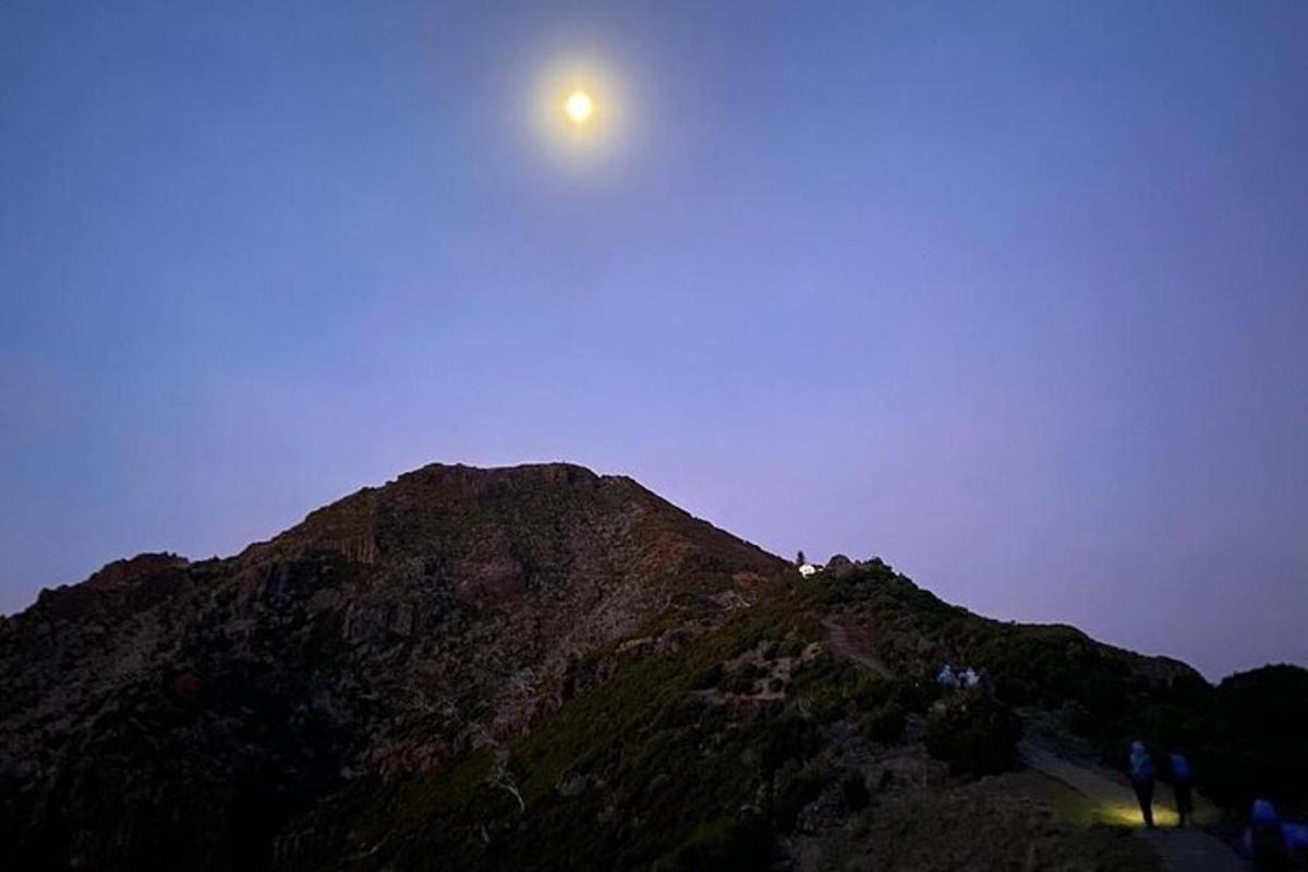 una luna seduta in cima a una montagna