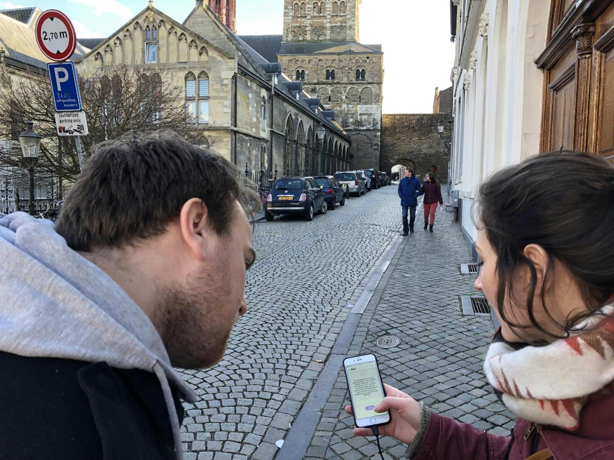 muž a žena se dívají na mobilní telefon na ulici