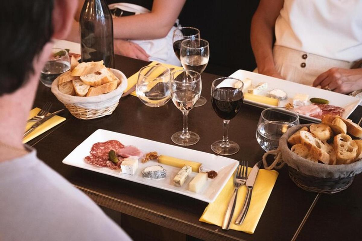 a table with a plate of food and glasses of wine