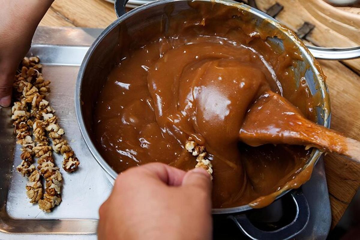seseorang sedang menambahkan selai kacang dan kenari ke dalam wajan