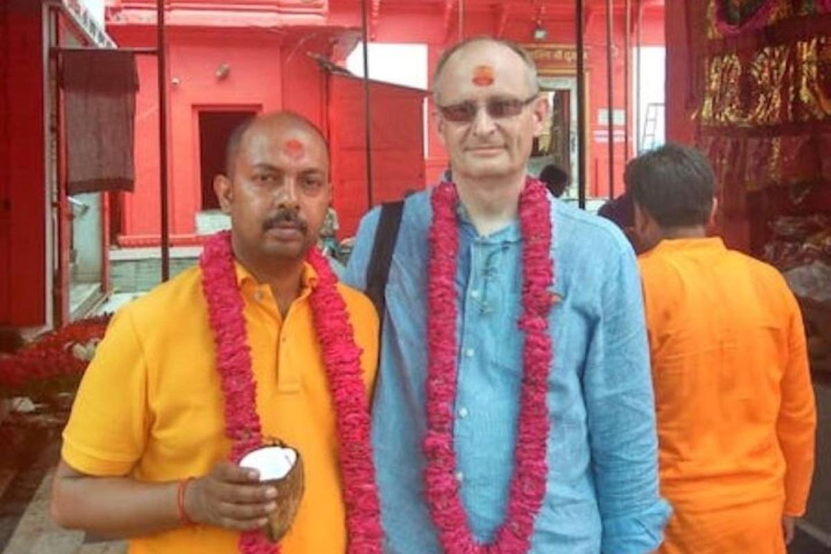 two men wearing red ropes standing next to each other