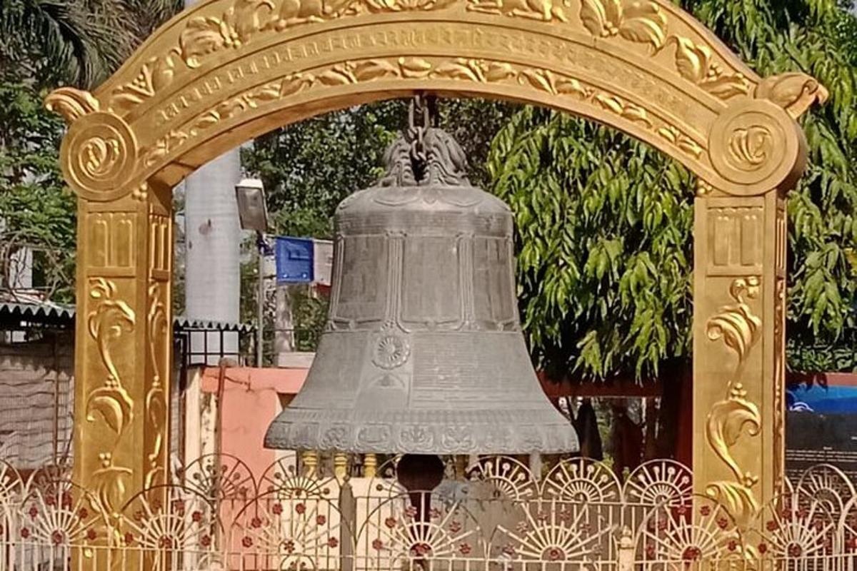 a large bell hanging from a gold gate