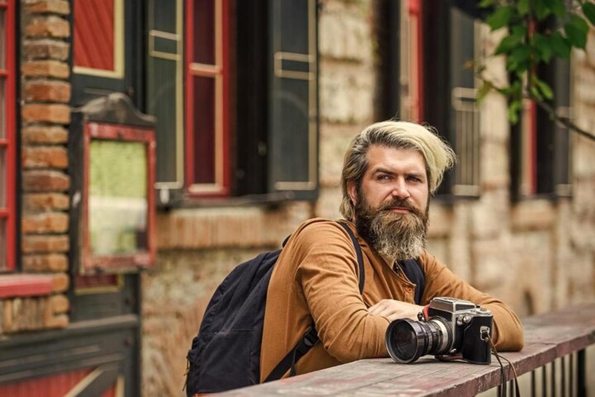 maður með myndavél sitjandi á bekk