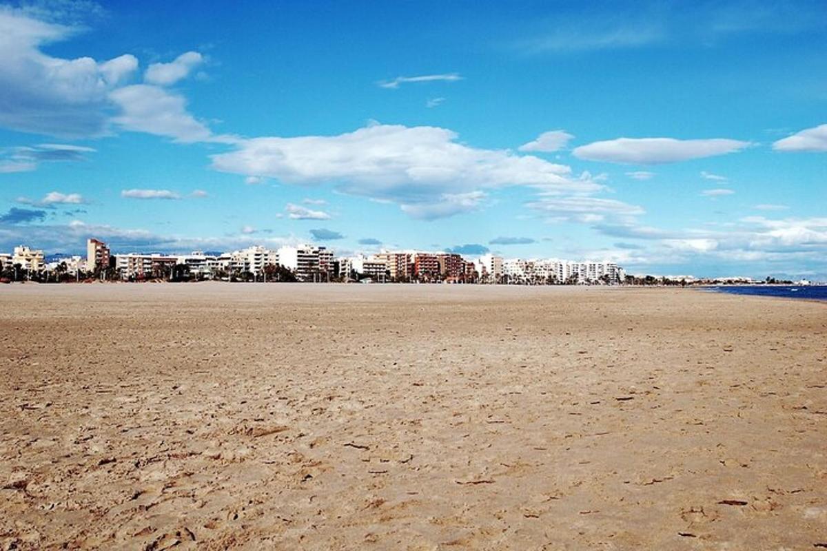 una platja de sorra amb una ciutat al fons