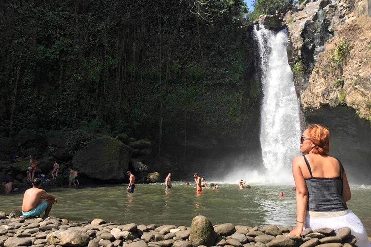 una donna seduta sulle rocce davanti a una cascata