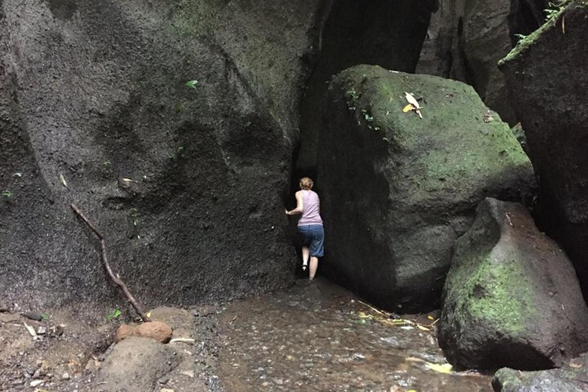 una donna in piedi accanto a una grande roccia