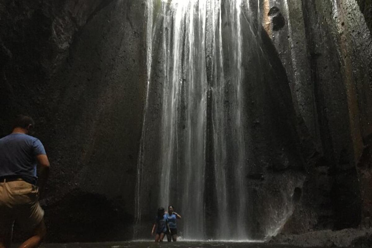 un gruppo di persone in piedi davanti a una cascata