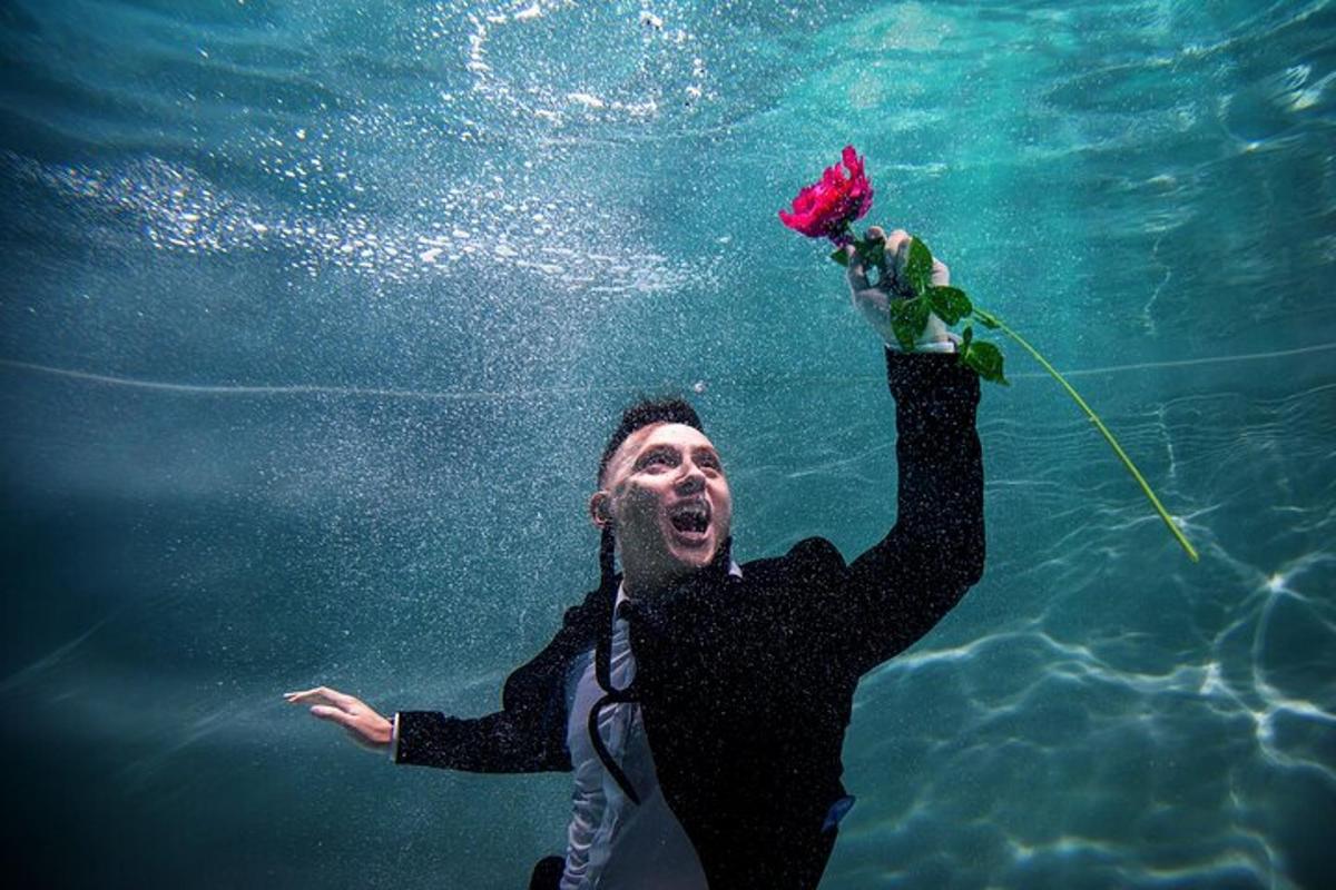a man swimming in the water with a flower in the water