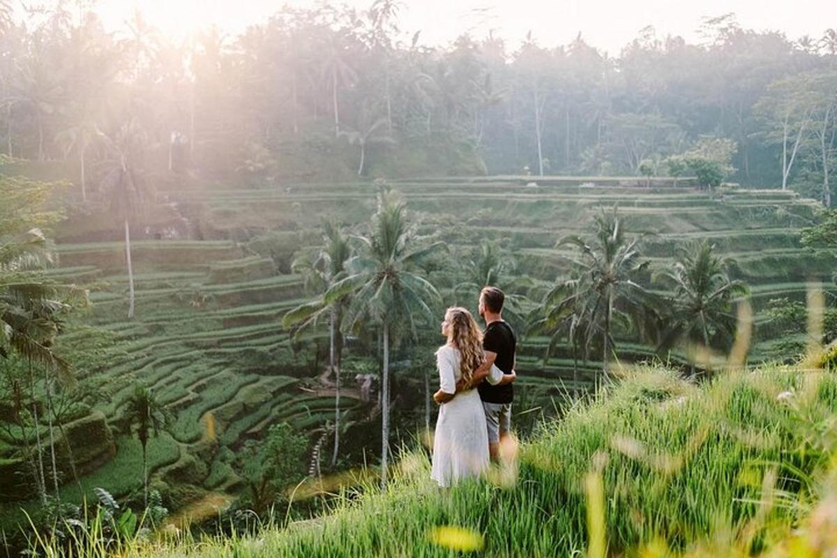 Una novia y un novio de pie frente a un campo de arroz