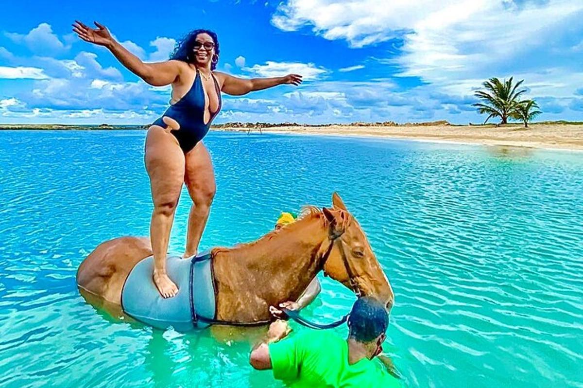 žena stojící na koni ve vodě