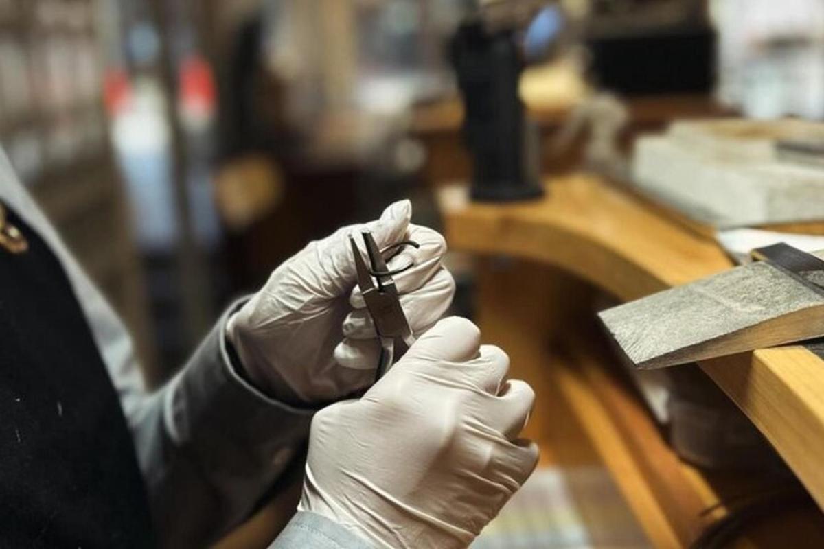 a person in gloves writing on a wooden table