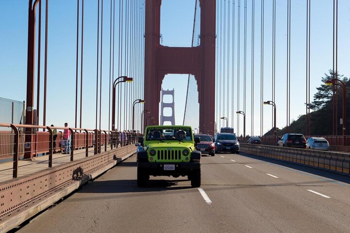Un jeep verde circulando por el puente Golden Gate