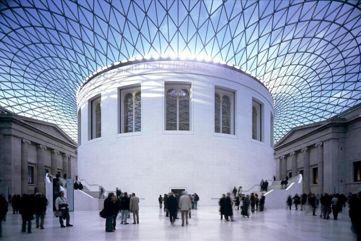 a crowd of people walking around a building with a glass ceiling