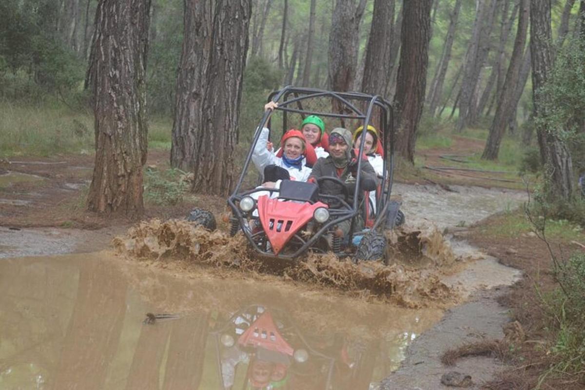 eine Gruppe von Menschen, die auf einem Quad im Schlamm fahren