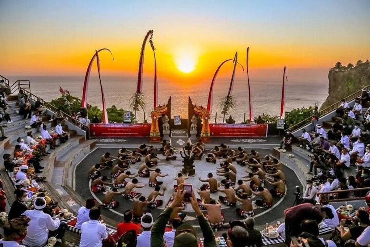 una folla di persone che guarda uno spettacolo al tramonto