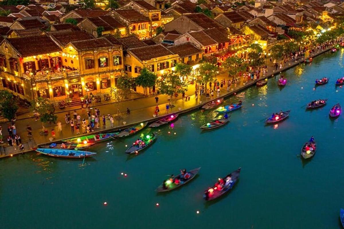 un gruppo di barche in un fiume con edifici