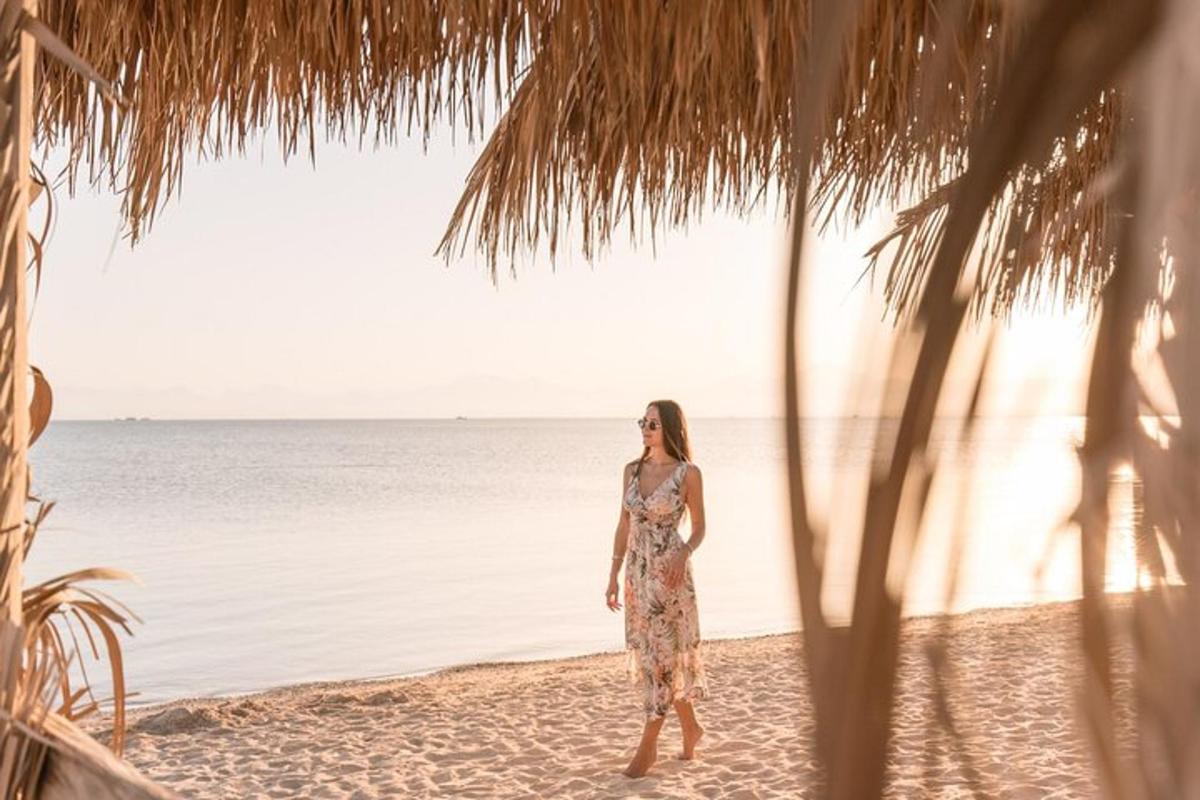 Μια γυναίκα με φόρεμα περπατάει στην παραλία