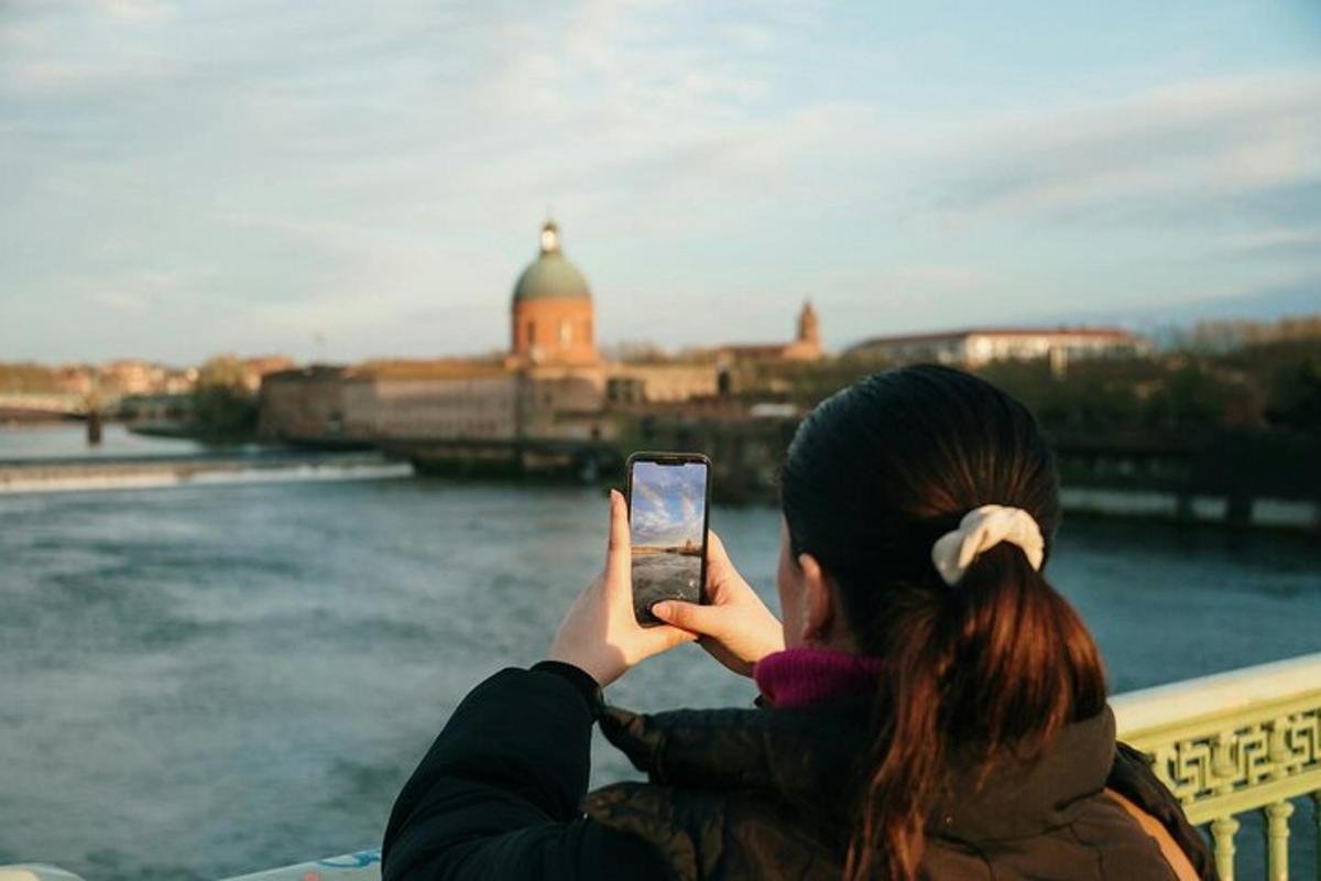 una donna che scatta una foto di un fiume con il suo cellulare
