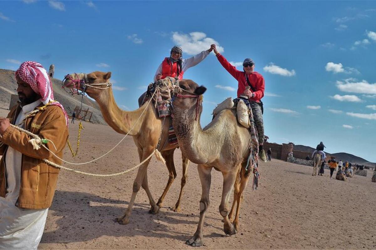 three men are riding on camels in the desert
