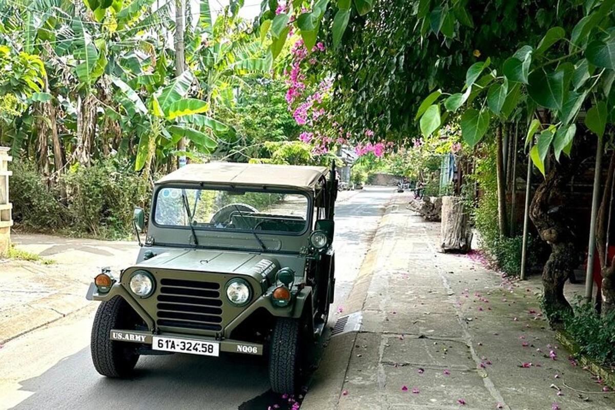 en grønn jeep parkert på siden av en gate