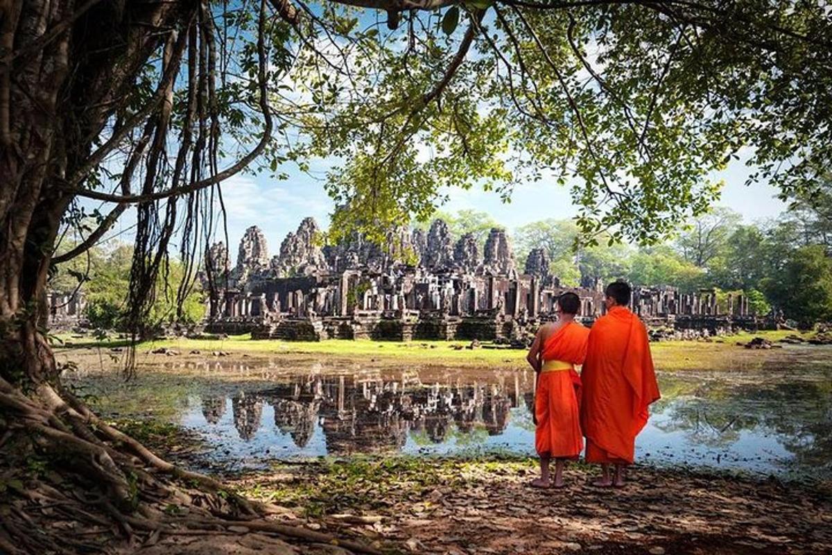 two men in orange robes standing in front of a temple