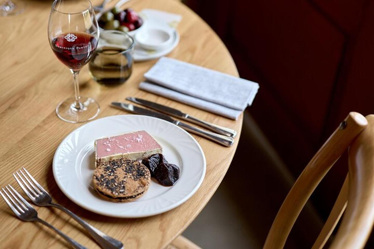 a table with a plate of food and a glass of wine