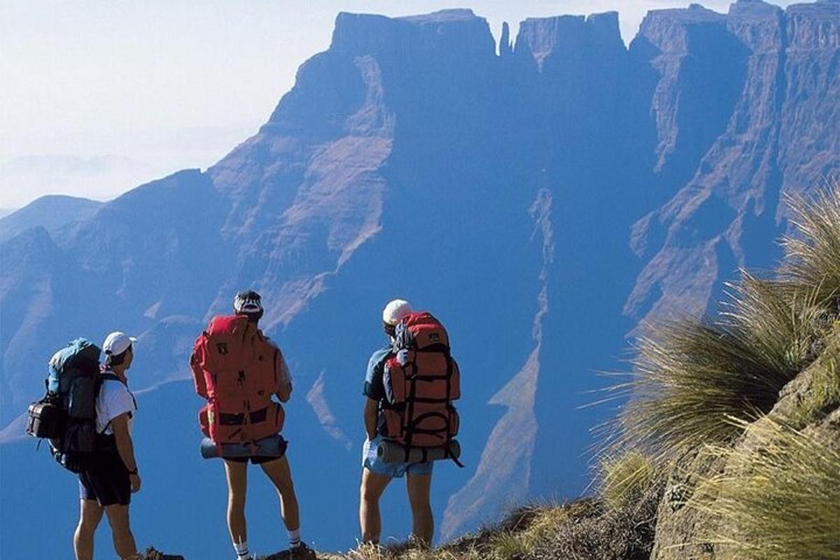 three people standing on a mountain looking at the view
