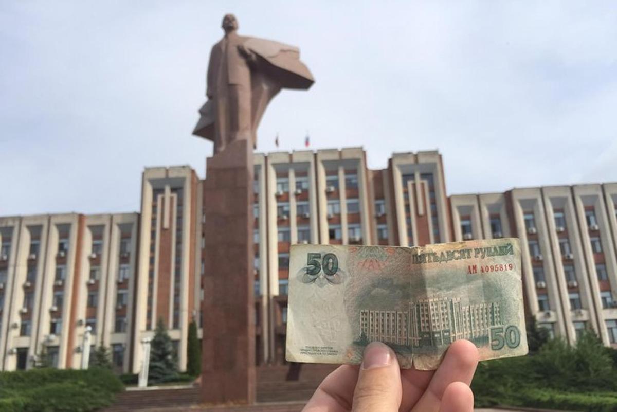 людина, яка тримає юань перед будівлею