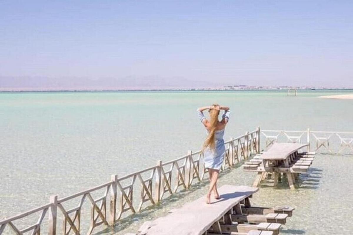 una donna in piedi su un molo che guarda l'acqua