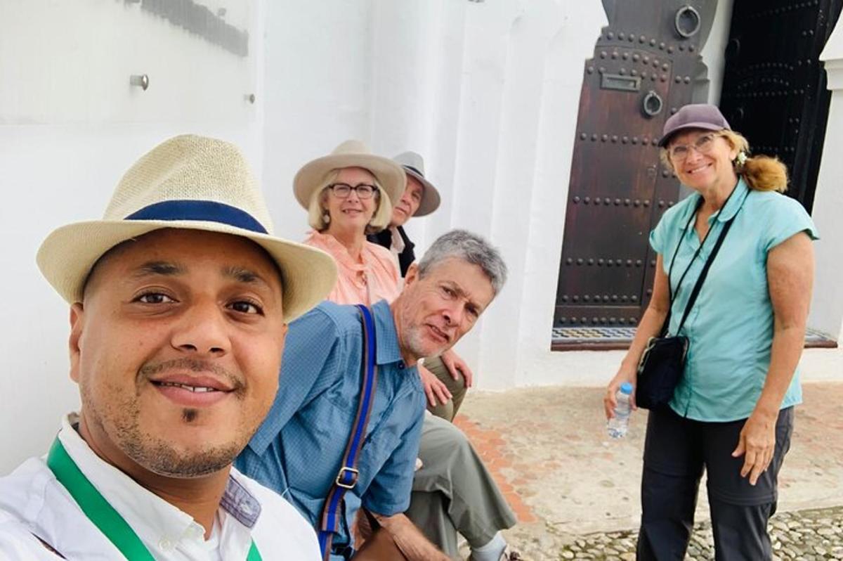 a group of people standing around a man wearing a hat