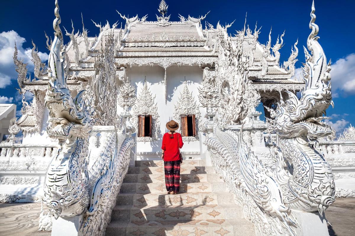 a woman standing in front of a white temple