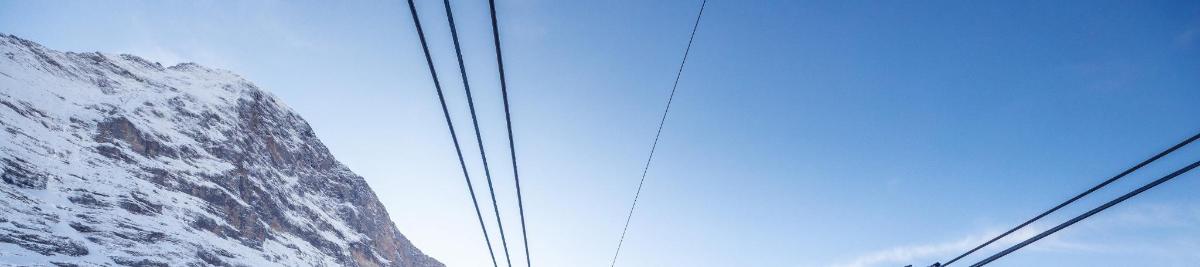 a pair of power lines in front of a mountain